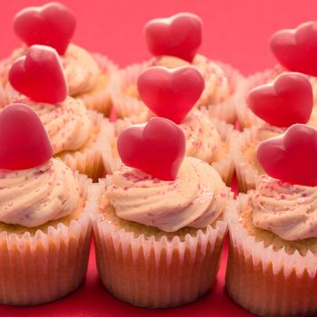 Valentines cupcakes with love hearts on pink background