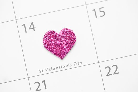 Pink glittering heart marking valentines day on white calendar