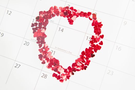 Confetti heart shape marking valentines day on white calendar