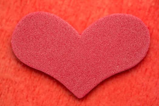 Red foam heart on red background
