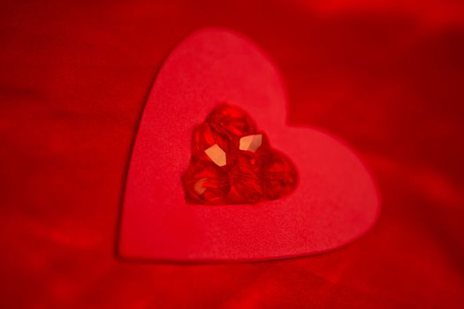 Rubies and paper red heart on red silk 