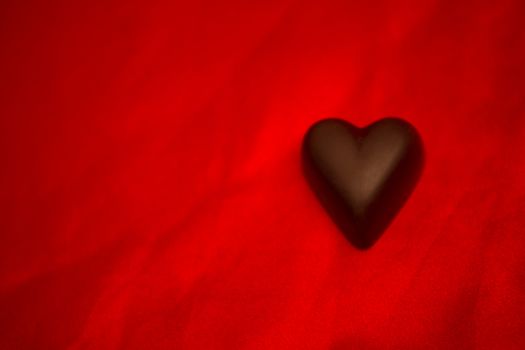 Chocolate heart on red silk