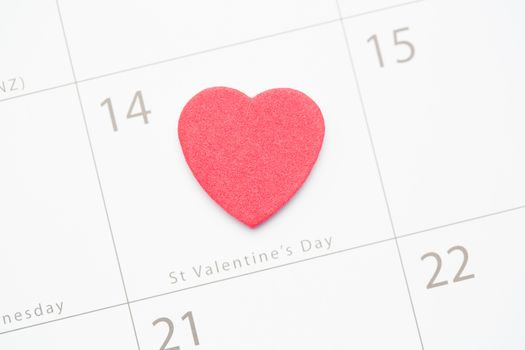 Pink confetti heart marking valentines day on white calendar