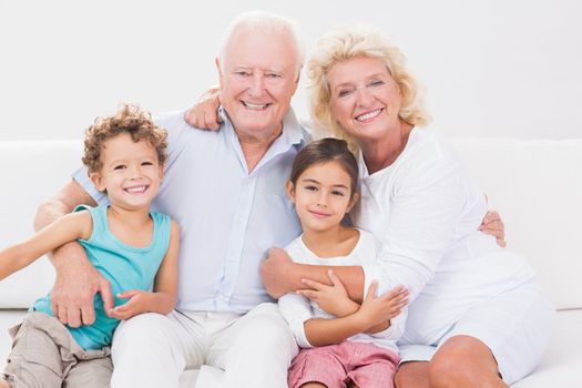 Cheerful grandparents with children on a sofa