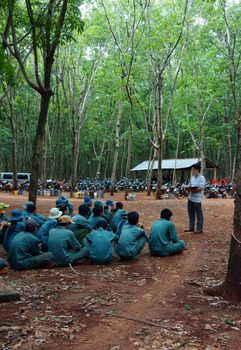 After working day, Dong Phu plantation's rubber worker meeting with team leader to report their work and listen affair content to next day. Binh Phuoc,Viet Nam-  May 9, 2013