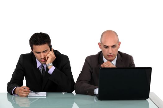 Serious businessmen working at a desk