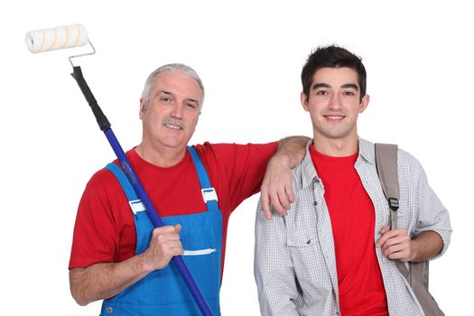 mature painter holding roller with young apprentice