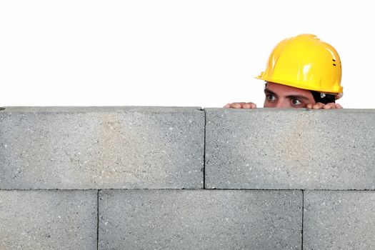 craftsman hiding behind a stone wall