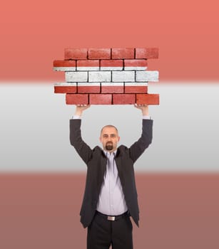 Businessman holding a large piece of a brick wall, flag of Austria, isolated on national flag