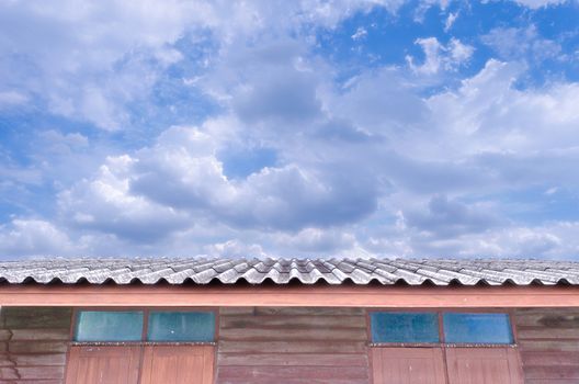 The Bright Cloudy Blue Sky over Roof of House.