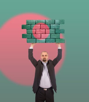 Businessman holding a large piece of a brick wall, flag of Bangladesh, isolated on national flag