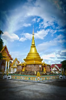 The Thai Golden Phra Tad or Pagoga with Blue Cloudy Sky.