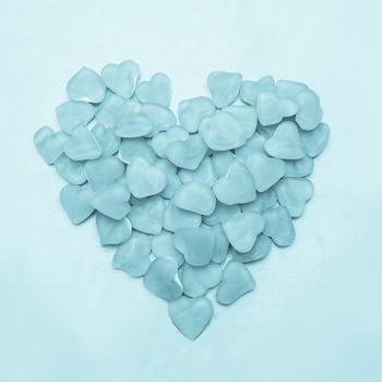 Blue heart made of candy on blue background