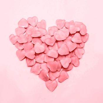 Heart made of pink candy on pink background