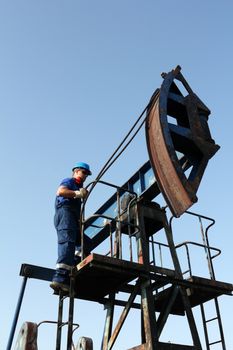 oil worker climb on pump jack