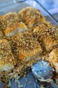 Classic Turkish Dessert tel kadayif garnished with walnuts ready to serve in a glass pan