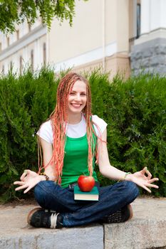 girl with a book meditating near the school