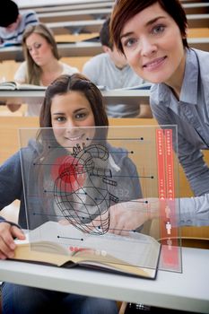 Teacher and student looking futuristic interface during lecture for studying