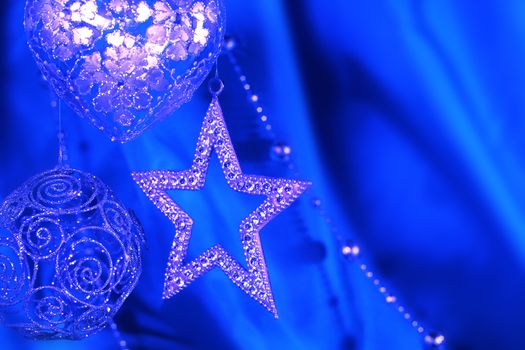 Silver christmas decoration on blue fabric background