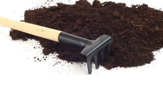 Rake and dirt isolated on white background, gardening concept