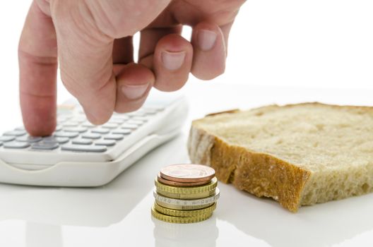 Slice of bread with Euro coins and male hand calculating monthly food expenses.