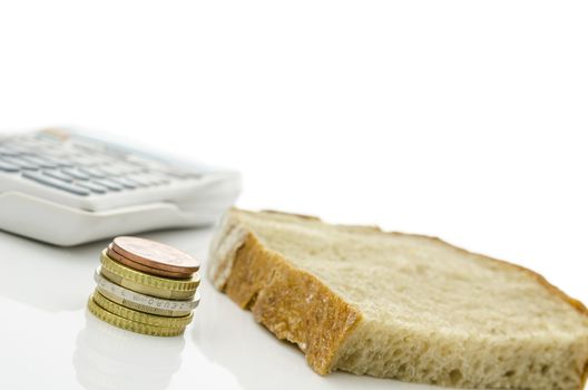 Slice of bread with Euro coins and calculator isolated on white background. Representing big monthly food expenses.