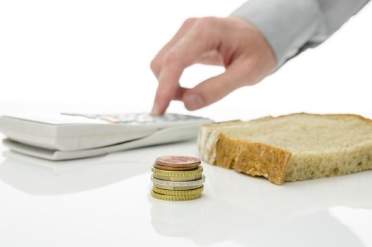 Slice of bread with Euro coins and male hand calculating monthly food expenses. Concept of difficult times and recession.