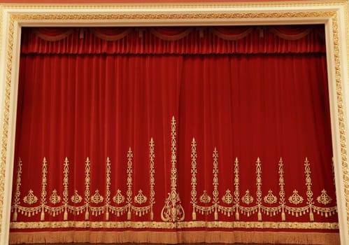Theatrical red velvet curtain with gold pattern