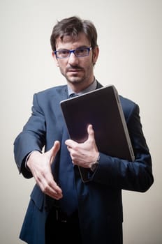 businessman with notebook holding out his hand on gray background