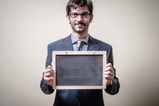 businessman holding blackboard on gray background