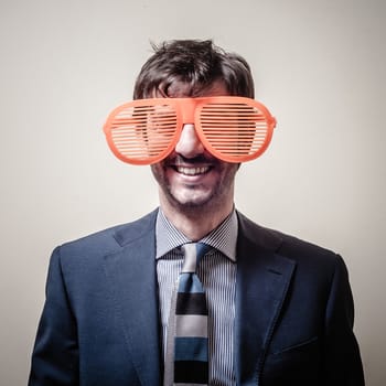 funny businessman with big orange glasses on gray background