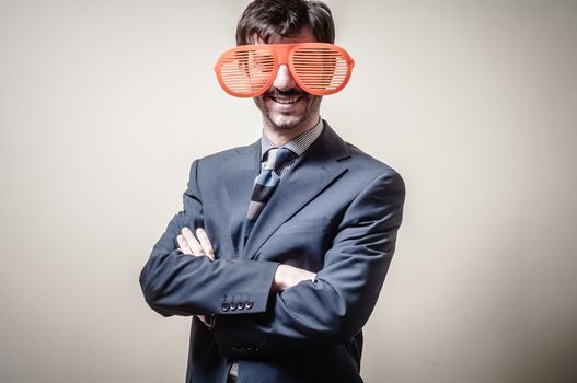 funny businessman with big orange glasses on gray background