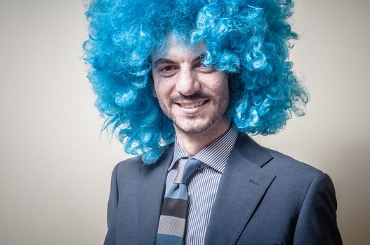 funny businessman with blue wig on  gray background