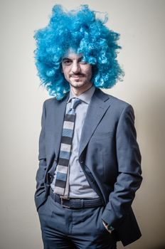 funny businessman with blue wig on  gray background
