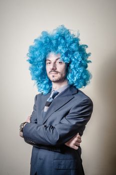 funny businessman with blue wig on  gray background