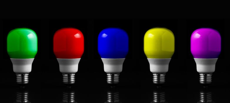 Colored light bulbs in row against black background