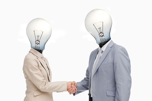 Business people with lightbulb heads greeting with a handshake against white background