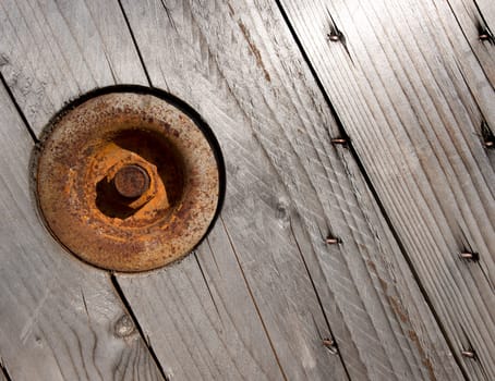 Background with wooden boards of pine, round rusty plaque and bolt