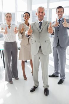 Group of business people giving thumbs up in the meeting room