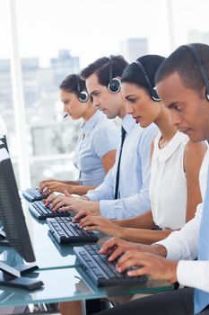 Call center employees sitting in line in a workplace