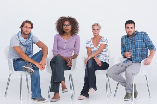 Stylish people sitting and looking at camera on white background