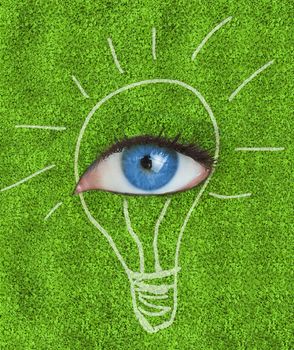 Blue eye surrounded by a drawing of a light bulb on grass texture