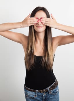 Beautiful young brunette woman covering her eyes