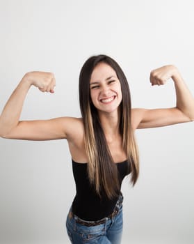 Beautiful young brunette woman flexing her biceps