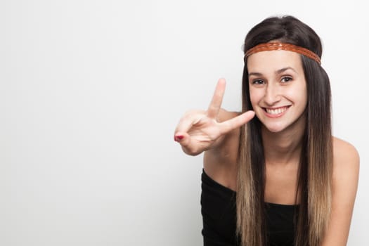 Young brunette woman posing with brown leather haed-band doing peace