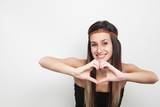 Young brunette woman posing with brown leather haed-band doing a heart