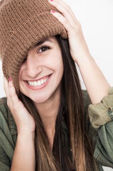 Young brunette woman doing funny face with brown hat