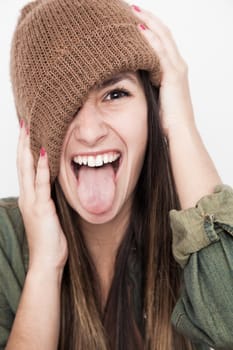 Young brunette woman doing funny face with brown hat