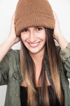 Young brunette woman doing funny face with brown hat