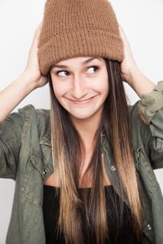 Young brunette woman doing funny face with brown hat